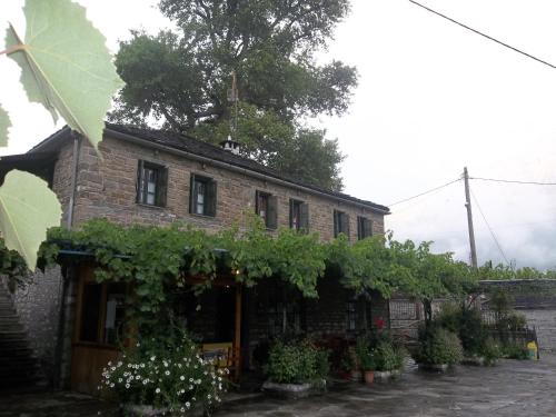 an old brick building with a bunch of plants at Lakis Rooms in Papigko