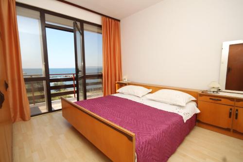 a bedroom with a bed and a large window at Apartment Nevidjane 8401a in Neviđane