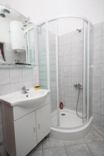 a white bathroom with a shower and a sink at Studio Nevidjane 8401a in Neviđane