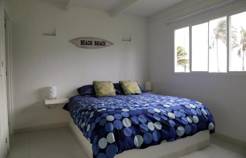 um quarto com uma cama com um edredão azul e branco em South End Villas em San Andrés