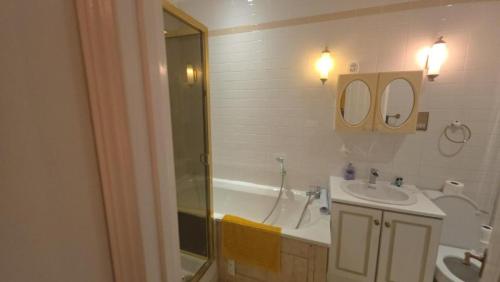 a bathroom with a tub and a sink and a shower at First Class Luxurious Apartment London Finchley in Brent Station