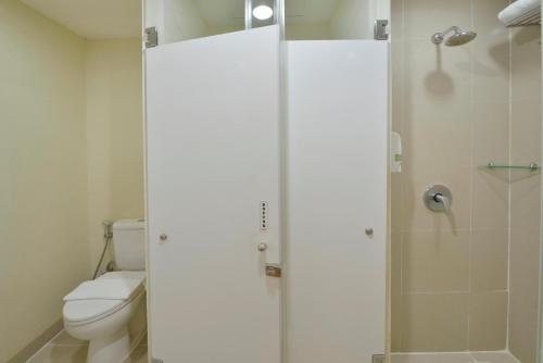 a bathroom with a toilet and a glass shower at Whiz Hotel Malioboro Yogyakarta in Yogyakarta