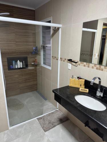 a bathroom with a sink and a shower at House in Santa Vitória Do Palmar in Santa Vitória do Palmar