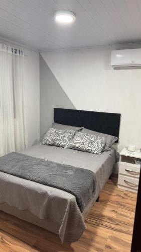 a bedroom with a bed with a black and white pillow at House in Santa Vitória Do Palmar in Santa Vitória do Palmar