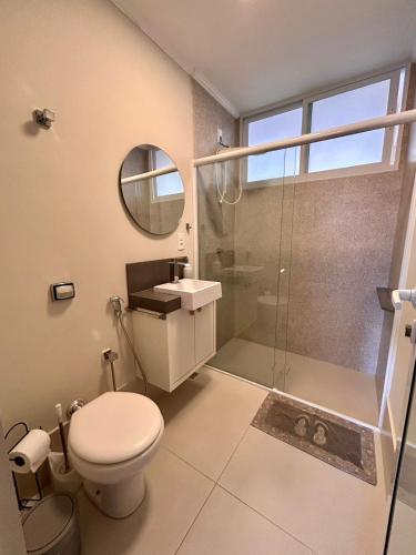 a bathroom with a toilet and a sink and a shower at Apto estúdio na praça central in Serra Negra