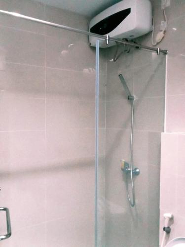 a shower in a bathroom with a glass door at Hotel Training Center UIN Mataram in Mataram