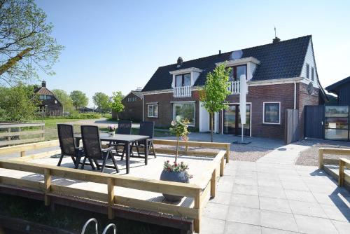 a patio with a table and chairs in front of a house at Gouden Plakje in Gaastmeer