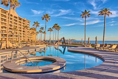 a resort with a swimming pool and palm trees at Oceanfront Sunsets at Sonoran Spa E305 in Puerto Peñasco