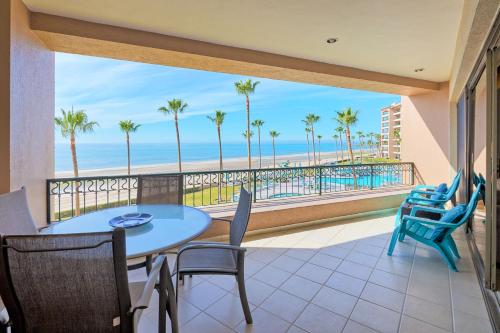 a balcony with a table and chairs and a view of the beach at Oceanfront Sunsets at Sonoran Spa E305 in Puerto Peñasco