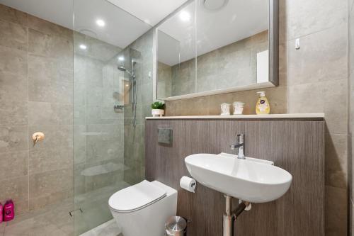 a bathroom with a sink and a toilet and a shower at SOP 82 Stylish and Cozy Two-Bedroom Apt in Sydney