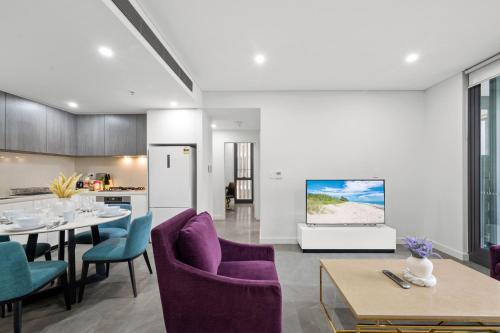 a living room with purple chairs and a kitchen at SOP 82 Stylish and Cozy Two-Bedroom Apt in Sydney
