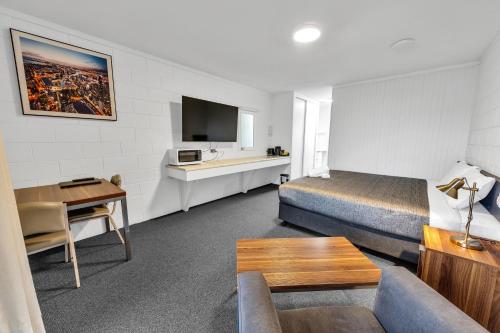 a hotel room with a bed and a couch and a table at Bendigo Motor Inn in Bendigo