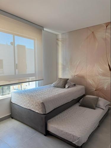 a bedroom with a large bed and a window at Casa Yireth in Ricaurte