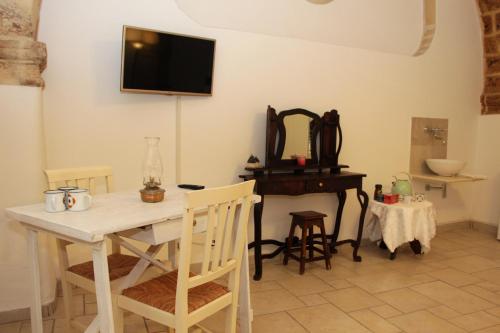 a dining room with a table and a television on the wall at Virginia B&B in Monopoli