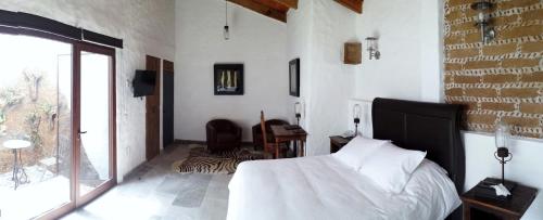 Rústika SPA Hotel Boutique في تيبوزتلان: غرفة نوم بها سرير ونافذة كبيرة