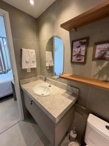 a bathroom with a sink and a mirror at Beach Class Verano 214 C in Ipojuca