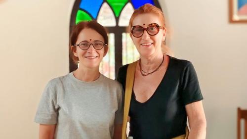 two women standing next to each other in front of a window at Anna's Heritage bungalow in Alleppey