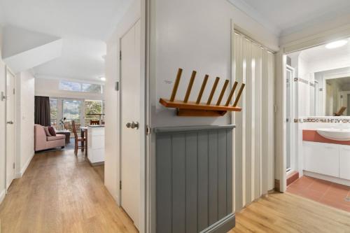 a hallway with a door with a chair on top at Inala 2 in Thredbo