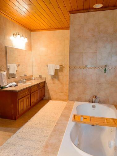 a large bathroom with a tub and a sink at 4 story Ocean Villa in Nassau