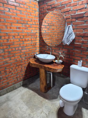 a bathroom with a sink and a toilet and a mirror at Alojamiento Mariana y Ocho Oñondive in Villa Concepción