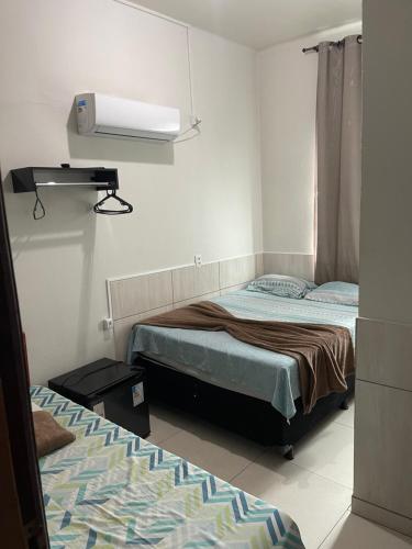 a bedroom with two beds and a light on the wall at Palace Hotel in Anápolis