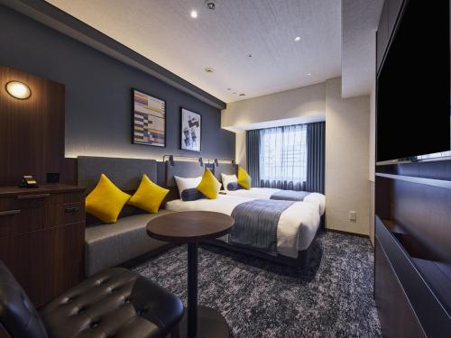 a hotel room with a bed and a couch at Villa Fontaine Kobe Sannomiya in Kobe
