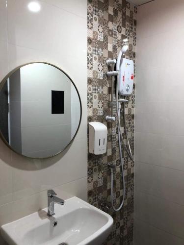 a bathroom with a sink and a mirror at TK Thongrak Apartment in Hat Yai
