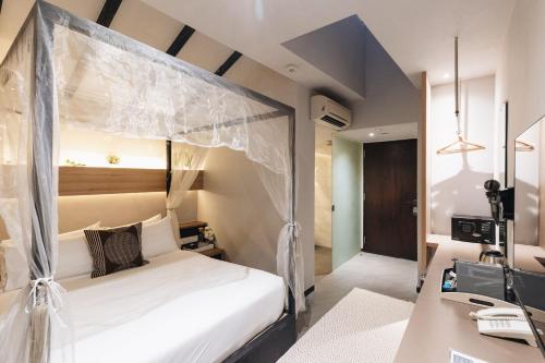 una camera da letto con un letto a baldacchino di Hotel NuVe a Singapore