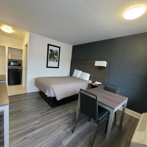 a hotel room with a bed and a table and a tableablish at Budget Inn in Durham