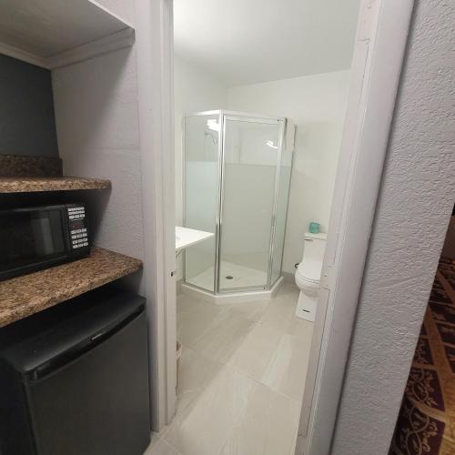 a bathroom with a glass shower and a toilet at Budget Inn in Durham