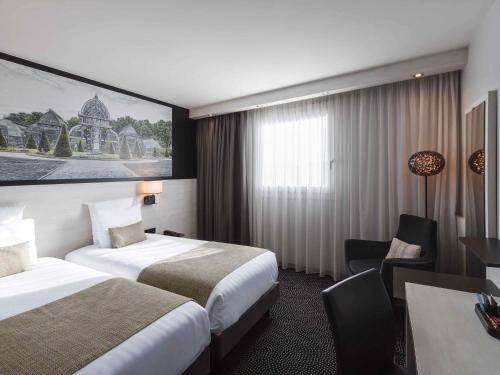 a hotel room with two beds and a desk at Hôtel Mercure Lyon Centre Charpennes Parc de la Tête d'Or in Villeurbanne