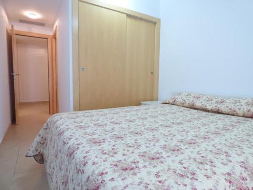 una camera da letto con un grande letto con una coperta floreale di Apartamento Santa Fe a Lloret de Mar