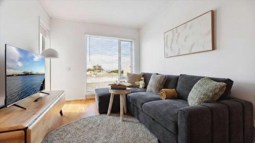 a living room with a couch and a tv at Stylish Apartment in Melbourne