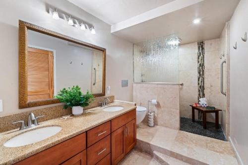 a bathroom with two sinks and a toilet and a shower at Lahaina Roads 209 in Lahaina
