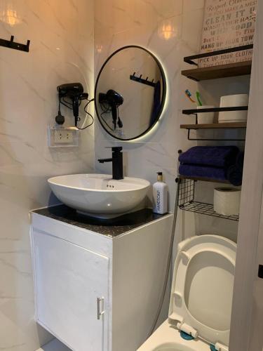 a bathroom with a sink and a mirror and a toilet at Gray Room The White Haven In Clark in Angeles