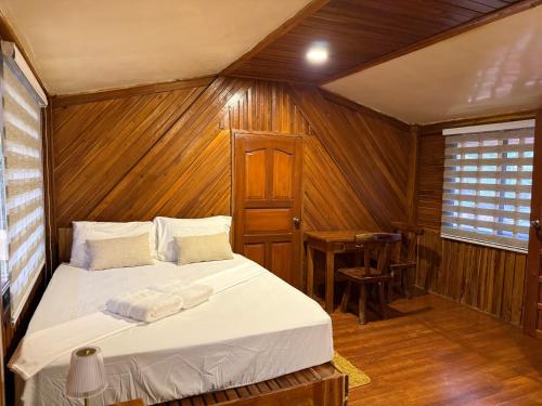 a bedroom with a bed in a wooden room at Leianna House in Itaytay