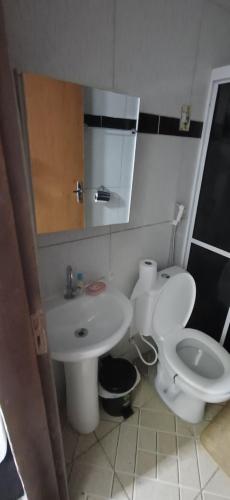 a bathroom with a white toilet and a sink at Pousada Lucas in Araruna
