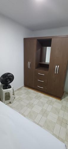 a room with a wooden cabinet and a stool at Pousada Lucas in Araruna