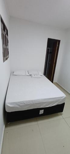 a bed sitting on the floor in a room at Pousada Lucas in Araruna