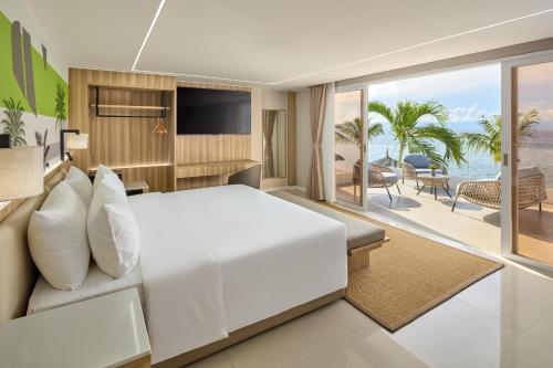 a bedroom with a bed and a view of the beach at LIME Resort Bohol, a member of Radisson Individuals Premier in Panglao Island