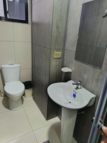 a bathroom with a white sink and a toilet at Hotel Virgen de las Peñas 2 in Oruro