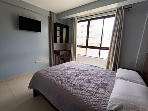 a bedroom with a bed and a window at Hotel Virgen de las Peñas 2 in Oruro