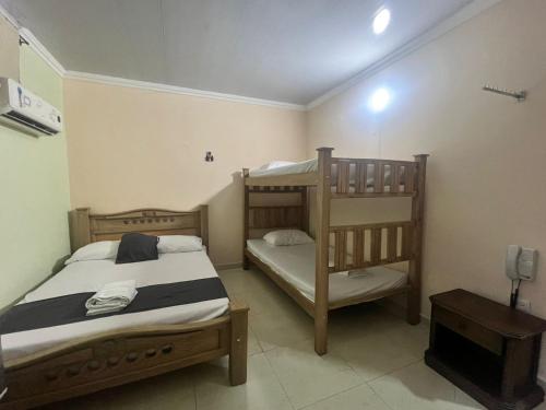 a bedroom with two bunk beds and a tv at Hotel Don Fermin in Barranquilla