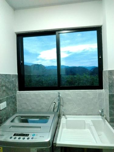 a kitchen with a sink and a window with a view at Cabaña Moderna a 1km del Centro de Tauramena in Tauramena