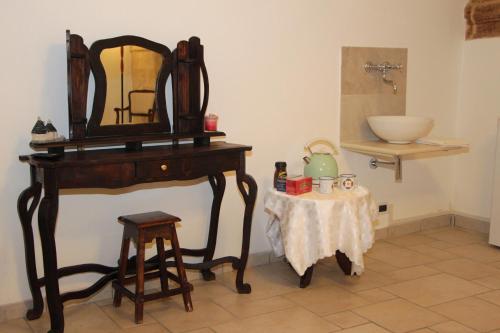 a vanity with a mirror and a table with a stool at Virginia B&B in Monopoli