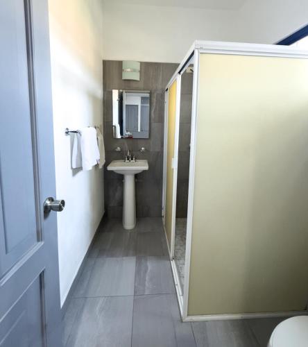 a bathroom with a sink and a shower door at Casa San Luis in Tuxtla Gutiérrez