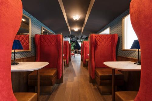 a train car with red seats and tables in it at Ruby Lissi Hotel Vienna by IHG in Vienna