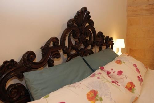 a bed with a wooden headboard and two pillows at Virginia B&B in Monopoli