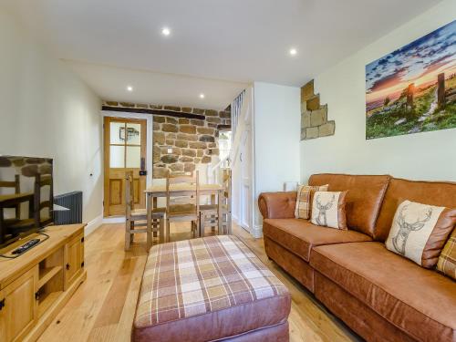 a living room with a couch and a table at Hidden Winds Cottage in Guisborough