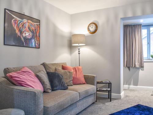 a living room with a couch and a clock at Corner Spot in Hednesford